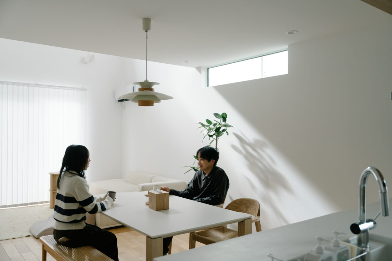 高窓から光が入り景色が映るダイニング