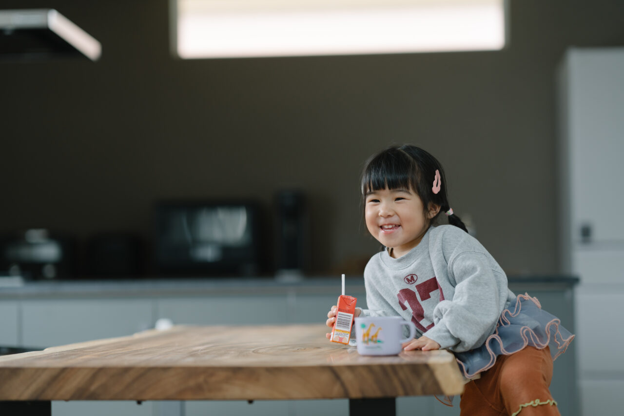 一枚板テーブルを家族みんなで囲う子どもの笑顔が家を明るくする